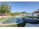 An inviting pool and spa with a waterfall feature, surrounded by lush landscaping and artificial grass at 22709 S 202Nd St, Queen Creek, AZ 85142