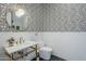 Stylish powder room with a geometric patterned wall, gold fixtures, and a modern sink at 22709 S 202Nd St, Queen Creek, AZ 85142
