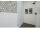 Modern walk-in shower with white subway tile, geometric accent wall, and black hexagon floor tiles at 22709 S 202Nd St, Queen Creek, AZ 85142