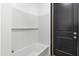 A bathroom features a tub and shower with tiled walls and a black door at 2689 S 305Th Ave Ave, Buckeye, AZ 85326