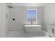 Modern bathroom with soaking tub, walk-in shower, and white tile at 2689 S 305Th Ave Ave, Buckeye, AZ 85326