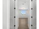 Bright hallway featuring wood floors and white trim leading to a bedroom at 2689 S 305Th Ave Ave, Buckeye, AZ 85326