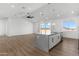 Open kitchen space featuring stainless steel appliances, gray countertop island and ceiling fan in this modern home at 2689 S 305Th Ave Ave, Buckeye, AZ 85326