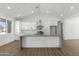 Open concept kitchen features modern white cabinets, gray countertops, stainless appliances, and pendant lighting at 2689 S 305Th Ave Ave, Buckeye, AZ 85326