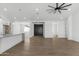 Open living and kitchen space includes light wood flooring, modern ceiling fan, and black front door at 2689 S 305Th Ave Ave, Buckeye, AZ 85326