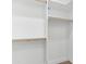 Bright walk-in closet featuring white walls, trim and shelving and wood closet rods at 2689 S 305Th Ave Ave, Buckeye, AZ 85326