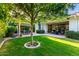 A well-manicured backyard showcases a patio with dining and lounge furniture, shaded by a mature tree at 2879 E Austin Dr, Gilbert, AZ 85296