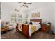 Cozy bedroom with a wooden sleigh bed frame, a ceiling fan, an accent chair, and bright natural light at 2879 E Austin Dr, Gilbert, AZ 85296