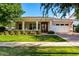 Inviting single-story home featuring a manicured lawn, brick-paved driveway, and charming covered front porch at 2879 E Austin Dr, Gilbert, AZ 85296