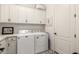 Bright laundry room with overhead cabinets, front load washer and dryer, and an adjacent utility sink at 2879 E Austin Dr, Gilbert, AZ 85296