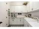 Clean laundry room with a utility sink, front load washer and dryer, decorative signs, and overhead cabinets at 2879 E Austin Dr, Gilbert, AZ 85296