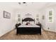 Well-lit main bedroom features a dark bed frame, neutral carpet, dual nightstands and decorative wall accents at 2879 E Austin Dr, Gilbert, AZ 85296