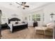 Spacious main bedroom featuring a dark bed frame, plush carpet, plantation shutters, and a cozy sitting area at 2879 E Austin Dr, Gilbert, AZ 85296