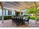 Outdoor dining on a covered patio with striped chairs and a well manicured lawn at 2879 E Austin Dr, Gilbert, AZ 85296