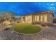 A view of the backyard with artificial turf and a covered patio at 31207 N 124Th Dr, Peoria, AZ 85383