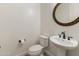 Powder room featuring a pedestal sink, bronze mirror, and toilet with mounted toilet paper holder at 31207 N 124Th Dr, Peoria, AZ 85383