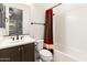 Bathroom featuring shower-tub combo with white tile and dark vanity with a mirror at 31207 N 124Th Dr, Peoria, AZ 85383