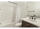 Clean bathroom featuring a shower-tub combo with white tile and a dark vanity with a mirror at 31207 N 124Th Dr, Peoria, AZ 85383