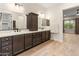 A dual sink bathroom features sleek cabinetry, a large mirror, and wood-look tile floors at 31207 N 124Th Dr, Peoria, AZ 85383