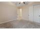 Bedroom featuring plush carpeting, a ceiling fan, and an ensuite closet and bathroom at 31207 N 124Th Dr, Peoria, AZ 85383