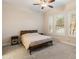 Bedroom with dual windows, wood bedside tables and a metal frame queen sized bed at 31207 N 124Th Dr, Peoria, AZ 85383
