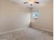 A bright bedroom features plush carpeting, ceiling fan, and a window offering natural light at 31207 N 124Th Dr, Peoria, AZ 85383