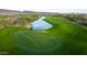 Beautiful golf course winding through a desert landscape with a tranquil lake, showcasing recreational opportunities at 31207 N 124Th Dr, Peoria, AZ 85383