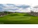 Scenic golf course view with lush green fairway, meticulously manicured green, and picturesque desert surroundings at 31207 N 124Th Dr, Peoria, AZ 85383