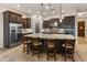 A spacious kitchen features dark wood cabinetry, stainless steel appliances, and a large island with seating at 31207 N 124Th Dr, Peoria, AZ 85383