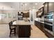 Open concept kitchen featuring dark wood cabinets, stainless steel appliances, and a granite island at 31207 N 124Th Dr, Peoria, AZ 85383
