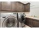 Modern laundry room features gray cabinets, countertop space and front load washer and dryer at 31207 N 124Th Dr, Peoria, AZ 85383