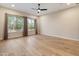 Bright living room features wood-look tile floors and large windows with outdoor views at 31207 N 124Th Dr, Peoria, AZ 85383