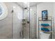 Bathroom shower featuring decorative glass enclosure, tiled walls, and shelving for a spa-like experience at 3160 E Fox St, Mesa, AZ 85213