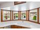 Kitchen sink area with white countertop, wooden cabinets, and a window view of the outdoor pool at 3160 E Fox St, Mesa, AZ 85213