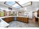 Spacious kitchen featuring a sunlit skylight and custom wood cabinetry at 3160 E Fox St, Mesa, AZ 85213