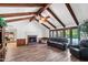 Cozy living room featuring a fireplace, wood-beamed ceiling, and access to the backyard at 3160 E Fox St, Mesa, AZ 85213