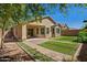 Landscaped backyard with a covered patio, brick walkway, and well-maintained lawn at 3221 W Alta Vista Rd, Phoenix, AZ 85041