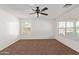 Spacious bedroom featuring neutral carpet, a ceiling fan, and bright windows at 3221 W Alta Vista Rd, Phoenix, AZ 85041