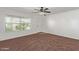 Inviting bedroom with neutral carpet, large window, and ceiling fan for comfort at 3221 W Alta Vista Rd, Phoenix, AZ 85041