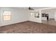 Open-concept room with neutral carpet and view into kitchen at 3221 W Alta Vista Rd, Phoenix, AZ 85041