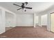 Open-concept living room with neutral carpet, ceiling fan, and abundant natural light at 3221 W Alta Vista Rd, Phoenix, AZ 85041