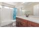 Bathroom featuring a tub, vanity with sink, toilet, white tile, and blue patterned shower curtain at 3424 E Harmony Ave, Mesa, AZ 85204