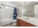 Well-lit bathroom with a bathtub and shower, vanity, and a floral shower curtain at 3424 E Harmony Ave, Mesa, AZ 85204