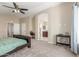 Spacious bedroom boasts neutral carpet, ceiling fan, and a view into the adjoining bathroom at 3424 E Harmony Ave, Mesa, AZ 85204