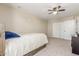 Bedroom features neutral carpeting, a ceiling fan, and double sliding door closet at 3424 E Harmony Ave, Mesa, AZ 85204