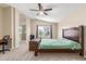 Bright bedroom with ceiling fan, neutral carpet, and doorway to the adjoining bathroom at 3424 E Harmony Ave, Mesa, AZ 85204