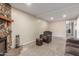 Comfortable living area with a stone fireplace and chair with ottoman at 3424 E Harmony Ave, Mesa, AZ 85204