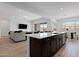 Modern kitchen featuring a large island with bar stools, seamlessly connected to the living and dining areas at 3885 E Kenley Ln, San Tan Valley, AZ 85143