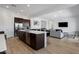 Open-concept kitchen and living room with a large island, bar seating, and stainless steel appliances at 3885 E Kenley Ln, San Tan Valley, AZ 85143