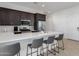 Stylish kitchen featuring stainless-steel appliances, dark wood cabinetry, and a quartz breakfast bar with seating at 3885 E Kenley Ln, San Tan Valley, AZ 85143